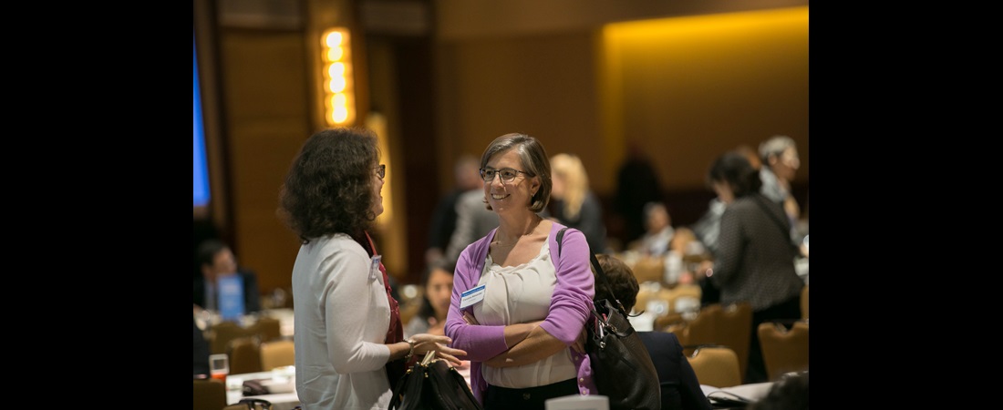 Two women speaking to each other at the conference
